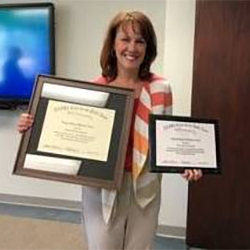 Beth Davis-Sramek is presented with the Being a Difference Award. Beth Davis-Sramek holding up the Being a Difference Award.