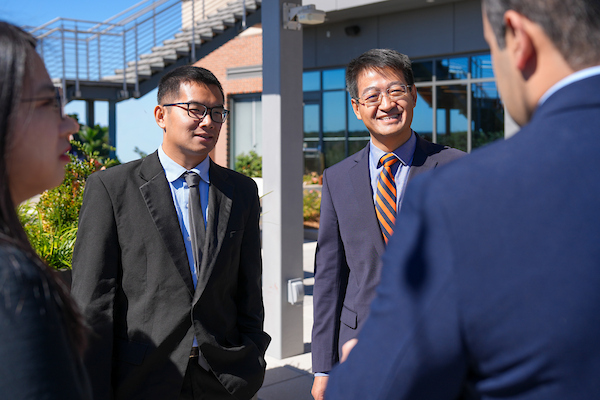 PhD in Business, Finance students smiling in front of Lowder Hall