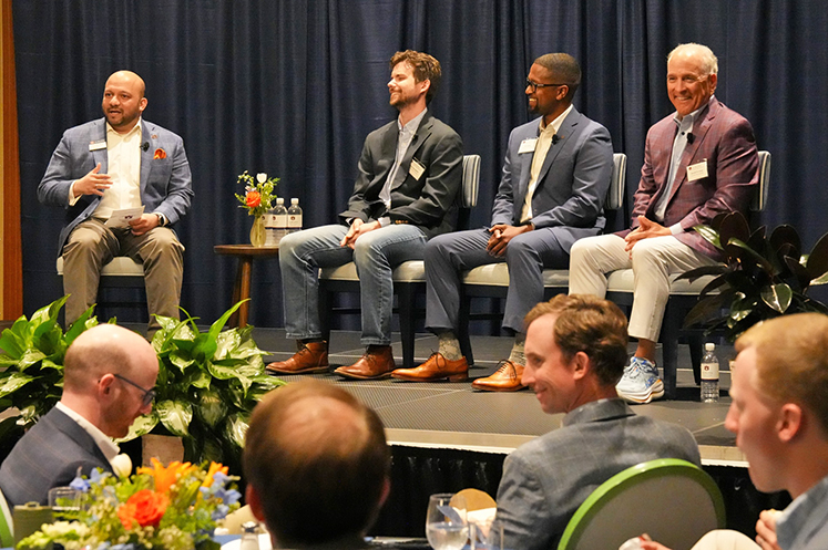 Four men talking to audience