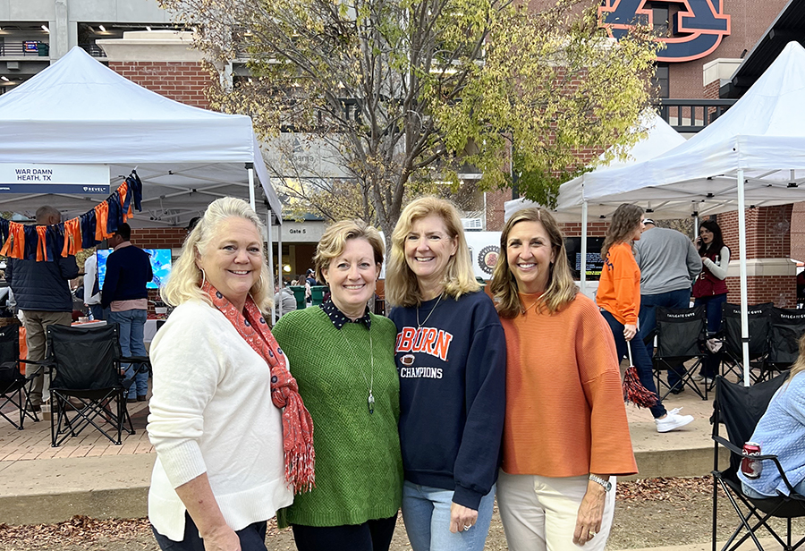 Four women standing outside football stadium