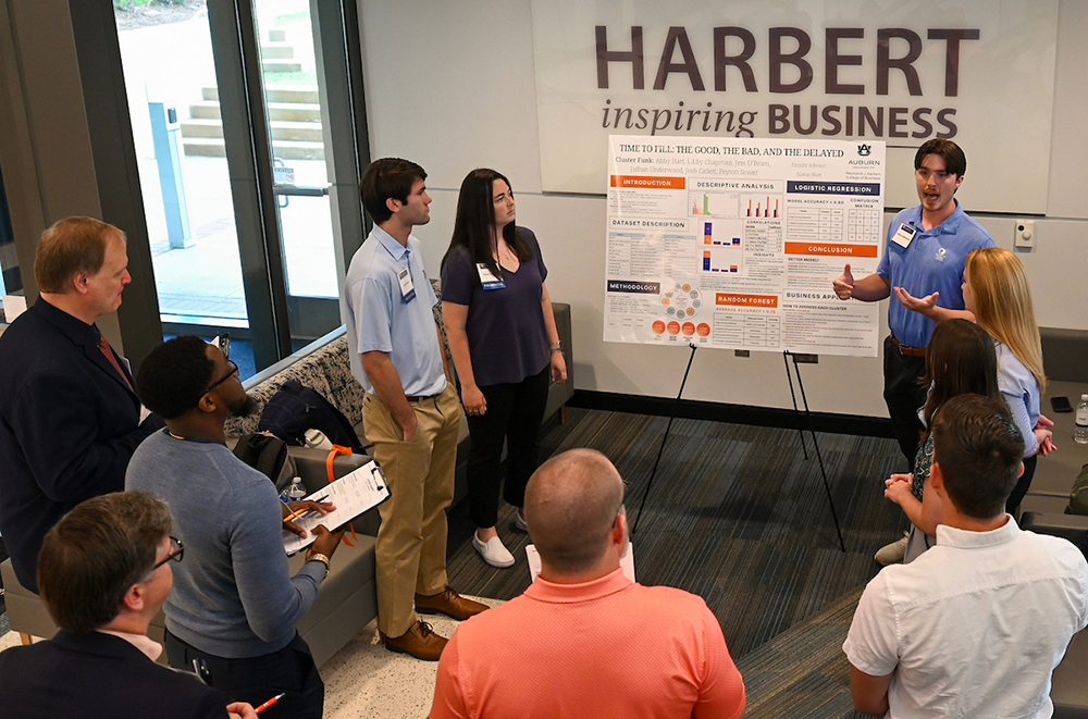 3 students discuss project with judges