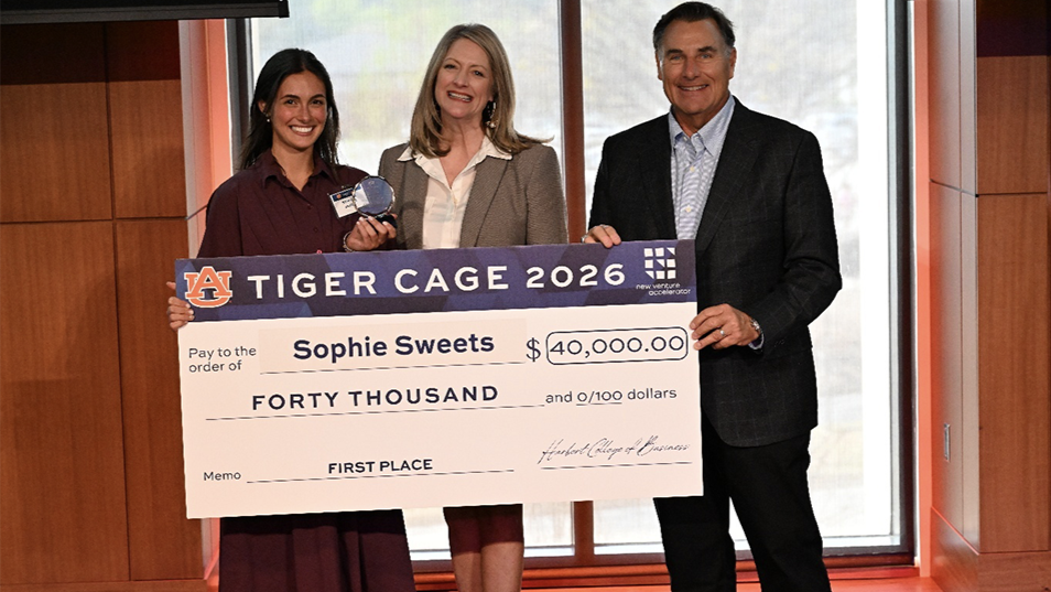 Three people holding prize check