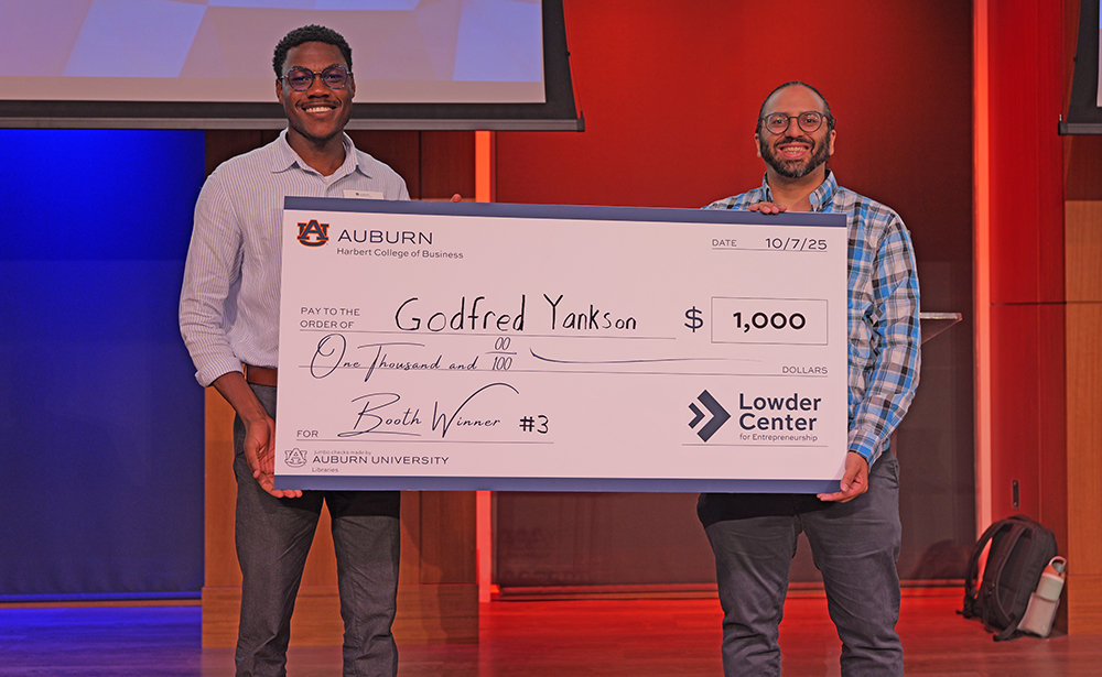 2 men holding giant check
