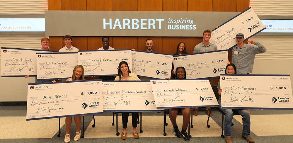 Multiple people holding giant checks