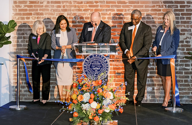 Auburn in Bham ribbon cutting ceremony Five people cutting ribbon in building