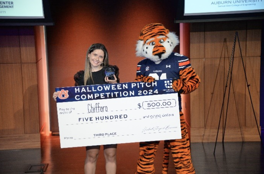 Student winner holding check with Aubie