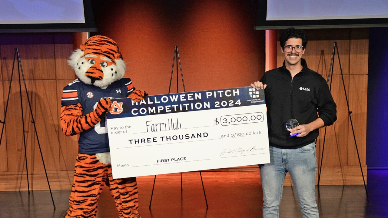 Farm Hub student holding check with Aubie