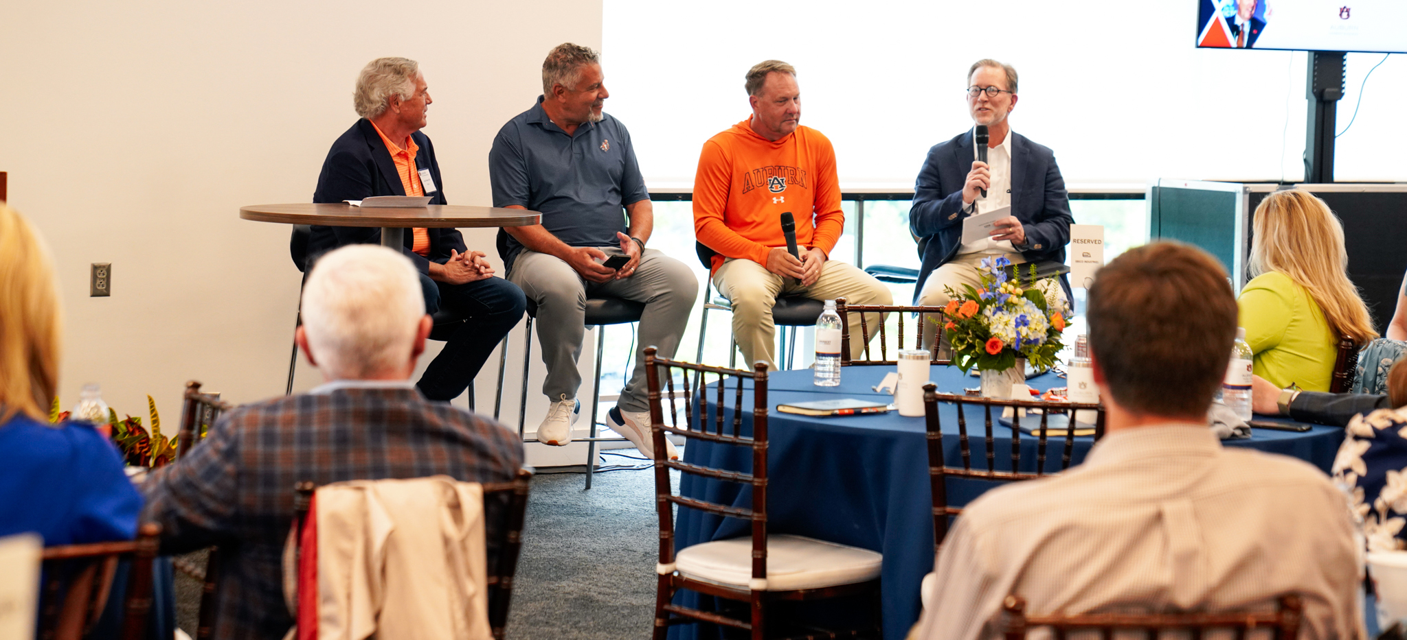 Coaches Walker Pierson Harbert Day24 four men sitting on chairs talking to audience
