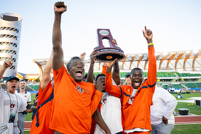 Auburn runners lifting trophy