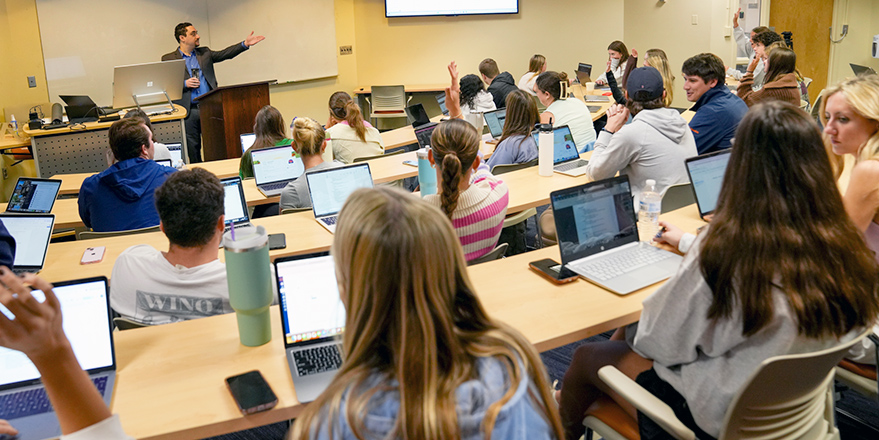 MKTG CRM course Salesforce training Man teaching students to use software in classroom