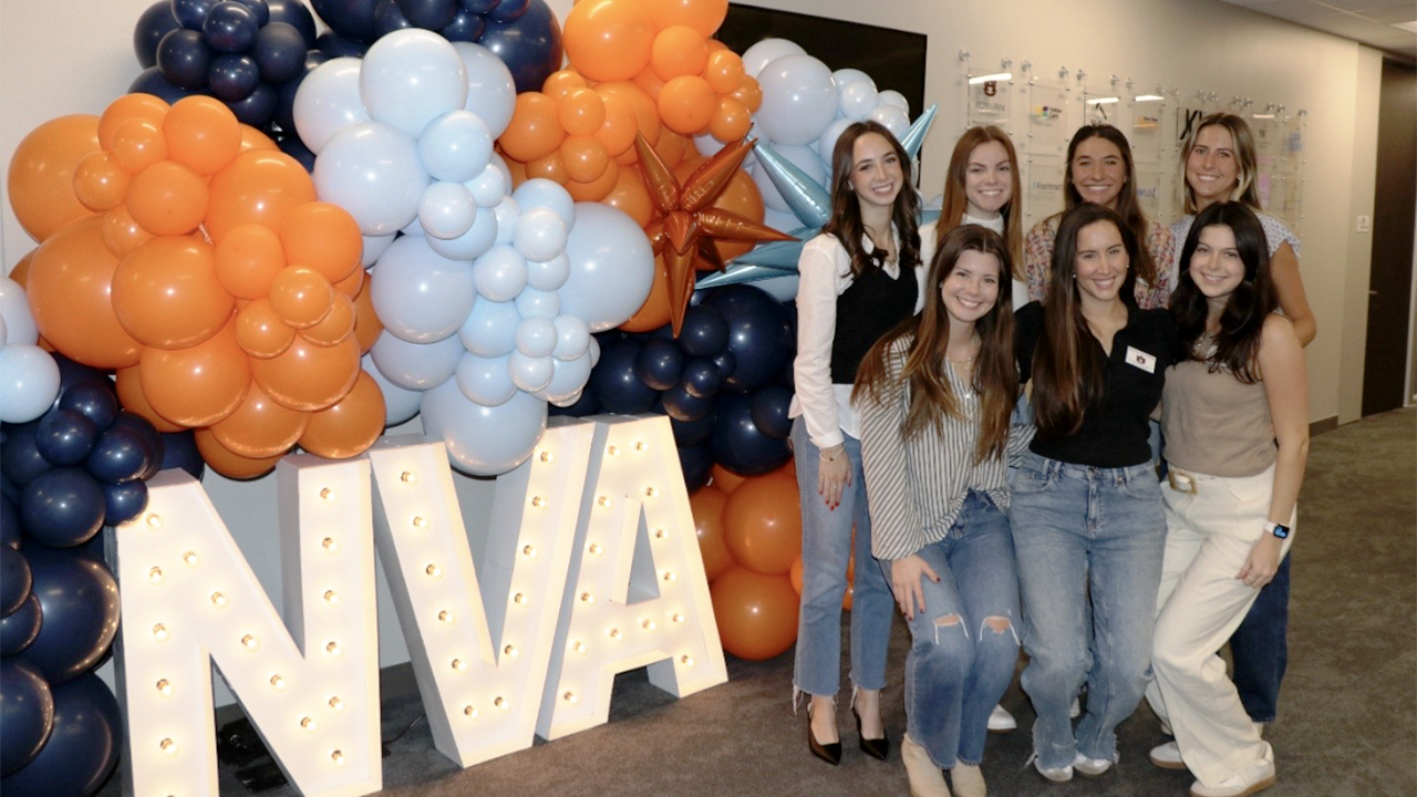 NVA interns Women students standing by NVA letter sign