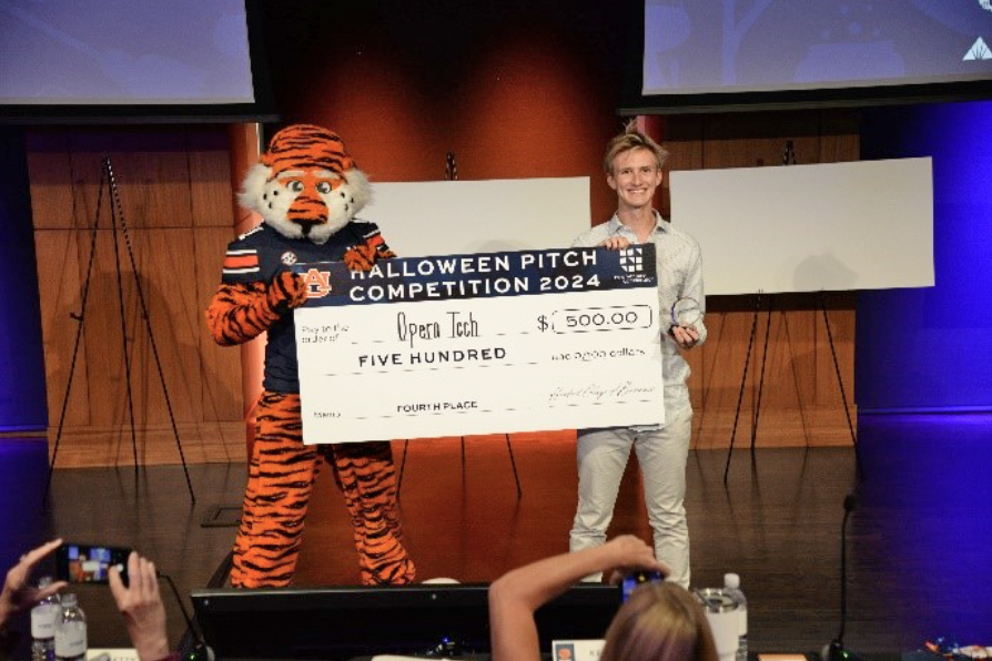 Student winner holding check wtih Aubie