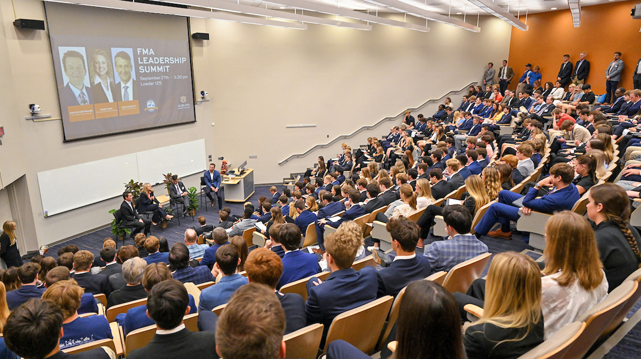 panelists in front of large seated crowd