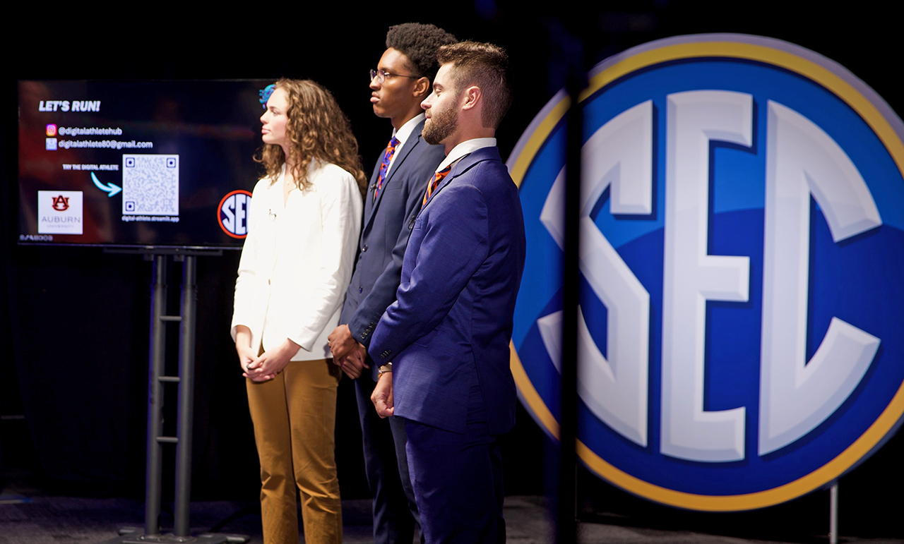 Allison Tanner and teammates Woman and two men on stage at SEC Startup competition