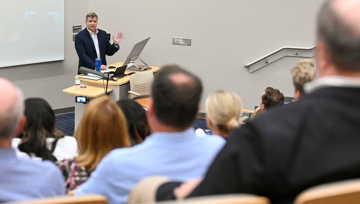 Mason Zimmerman Man lecturing at podium to audience