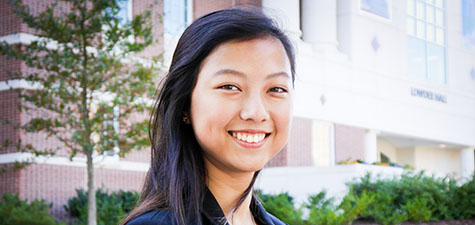 Student smiling in front of Lowder Hall