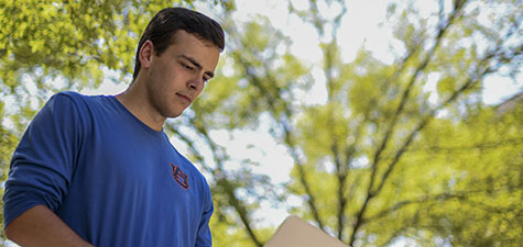 Student on computer outdoors