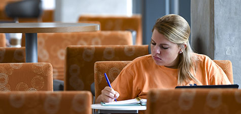 Student writing in planner in Horton-Hardgrave Hall
