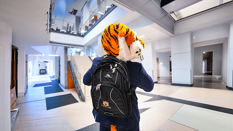 Aubie wearing Harbert backpack